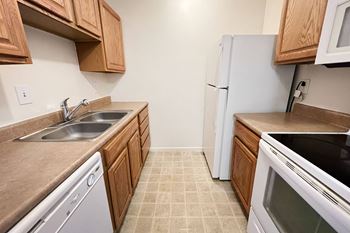 A kitchen with white appliances and wooden cabinets
